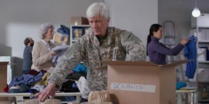 Military officer and volunteers preparing care packages for Veterans.